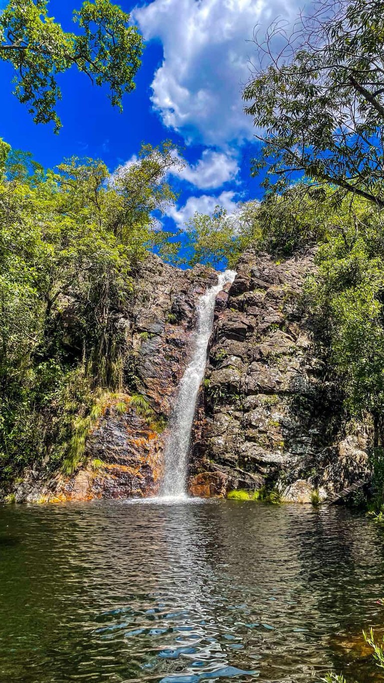 Queda d'água da Cachoeira Renascer em rocha alaranjada, no caminho para a Ponte de Pedra