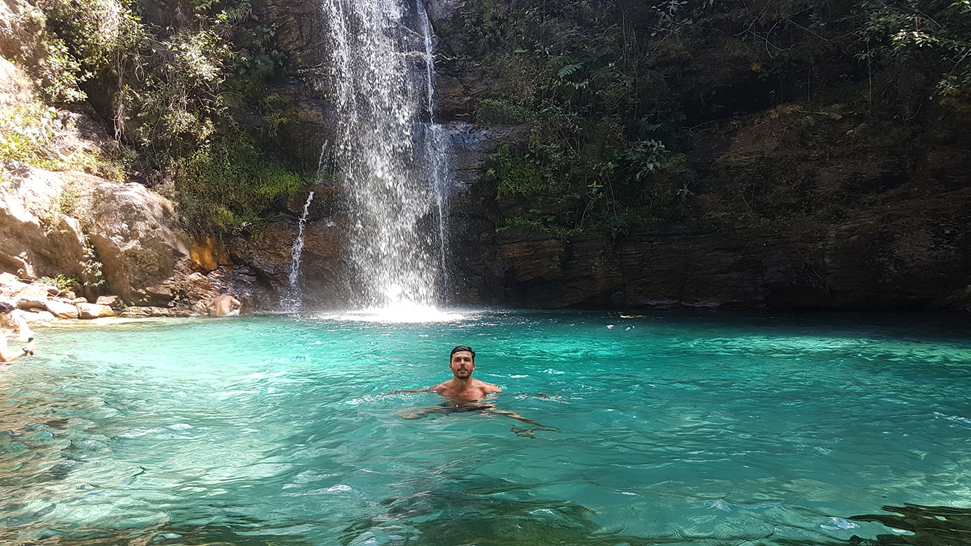 Turista boiando nas águas azul turquesa da cachoeira Santa Bárbara na Chapada dos Veadeiros