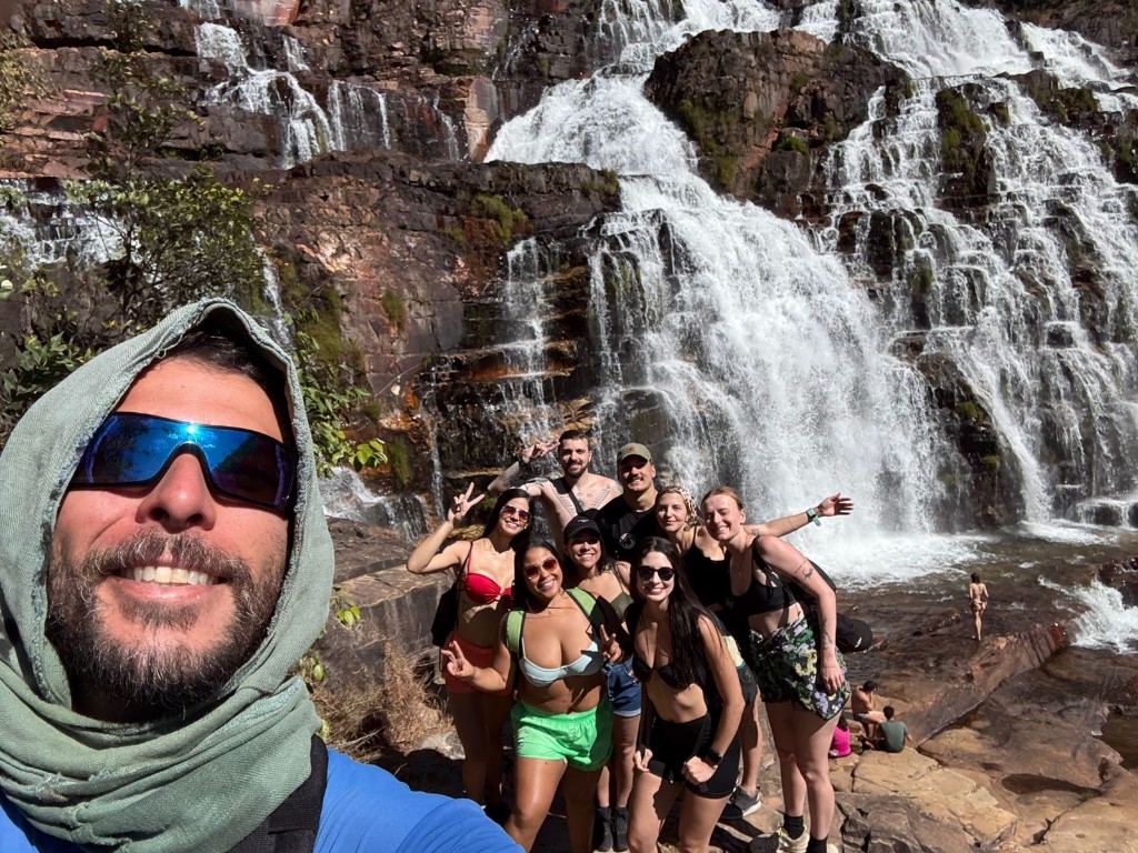 Grupo de turistas em selfie na base de cachoeira em degraus na Chapada dos Veadeiros com guia Cadastur